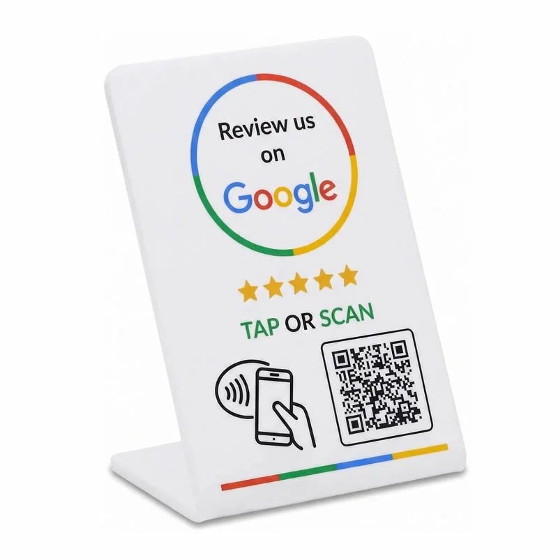 NFC stand on a counter showing a tap-to-review sign with QR code and NFC tap icon